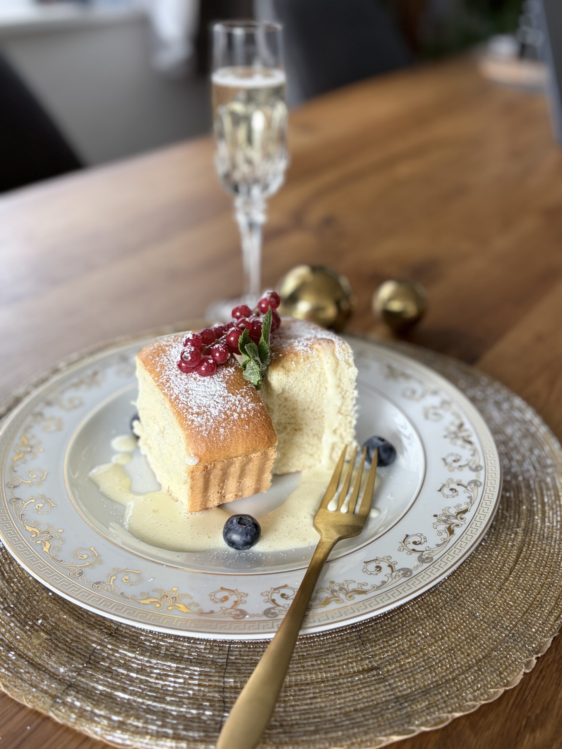 Buchteln auf Vanillesauce mit einem Glas Champagner